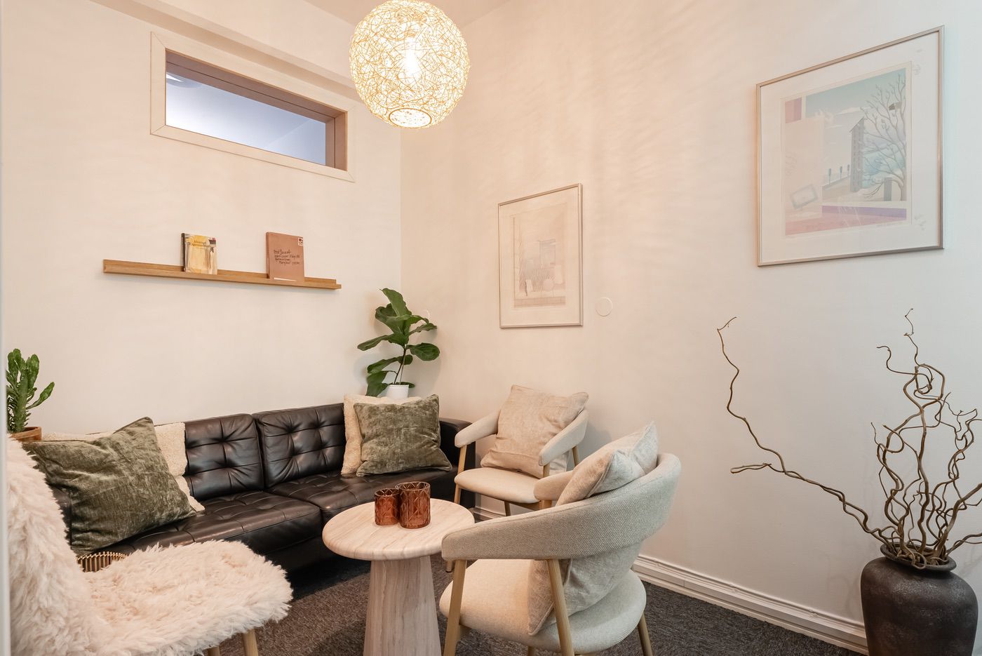 Mysigt vardagsrum med lädersoffa, fåtöljer och dekorativ belysning